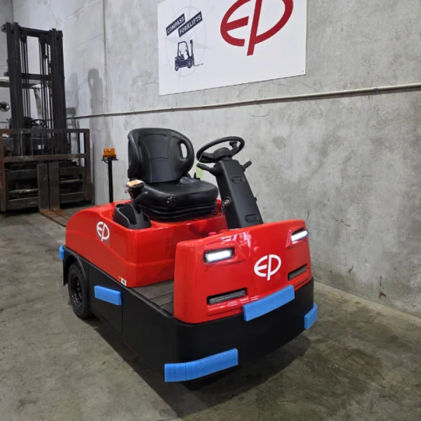 used electric tow tractor operating in a warehouse transport area